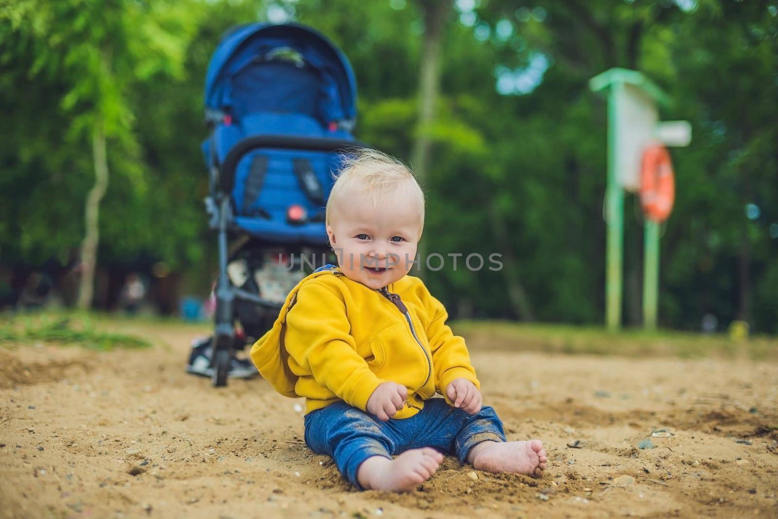 Toddler boy playing with sand on the beach development of fine motor skills by galitskaya