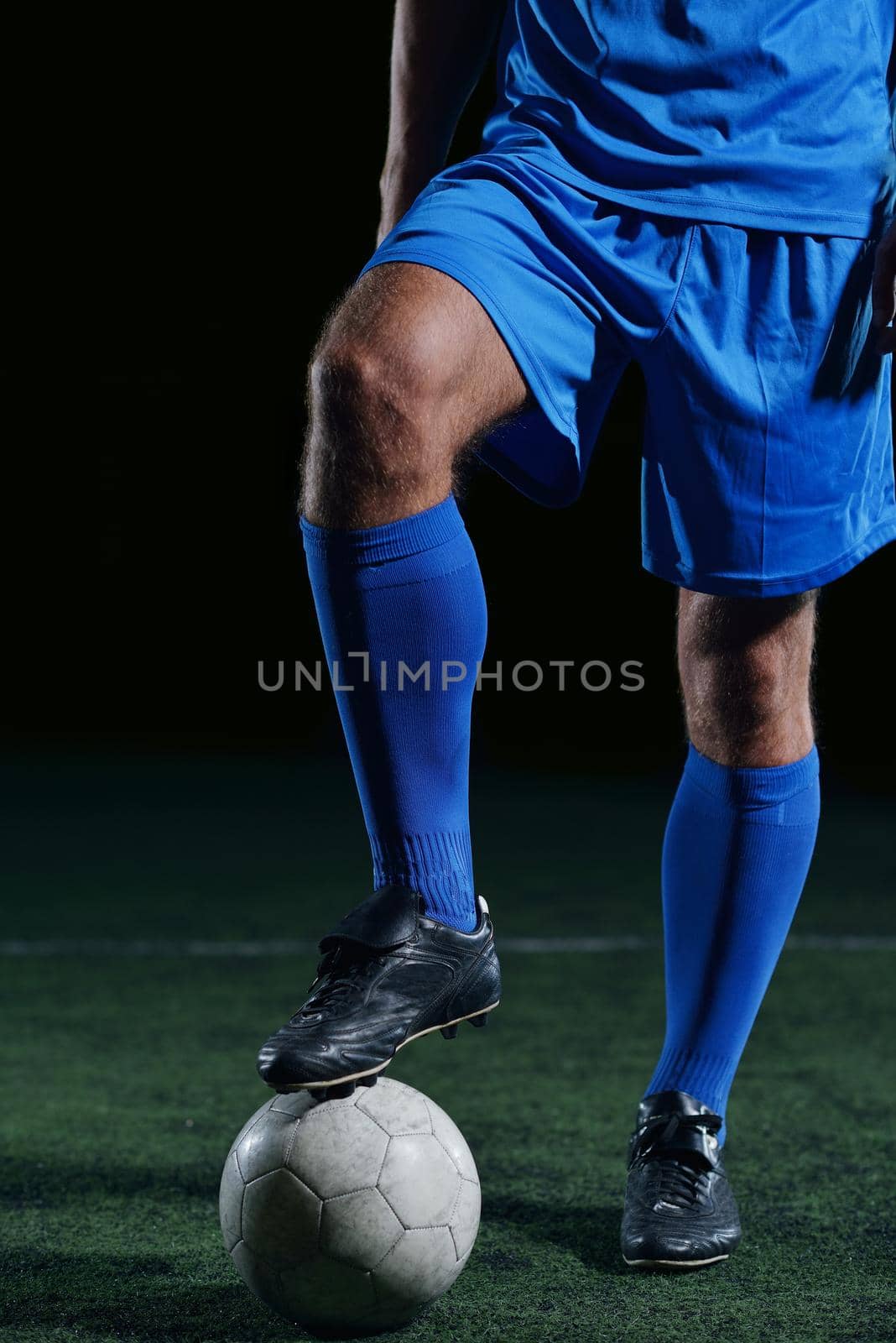 soccer player doing kick with ball on football stadium  field  isolated on black background