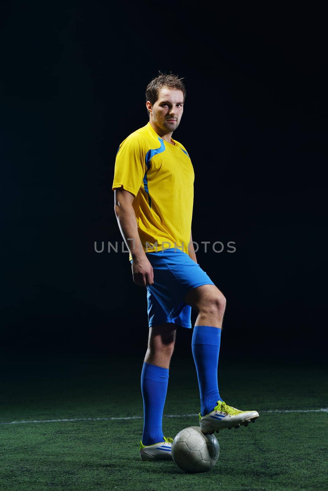 soccer player doing kick with ball on football stadium  field  isolated on black background