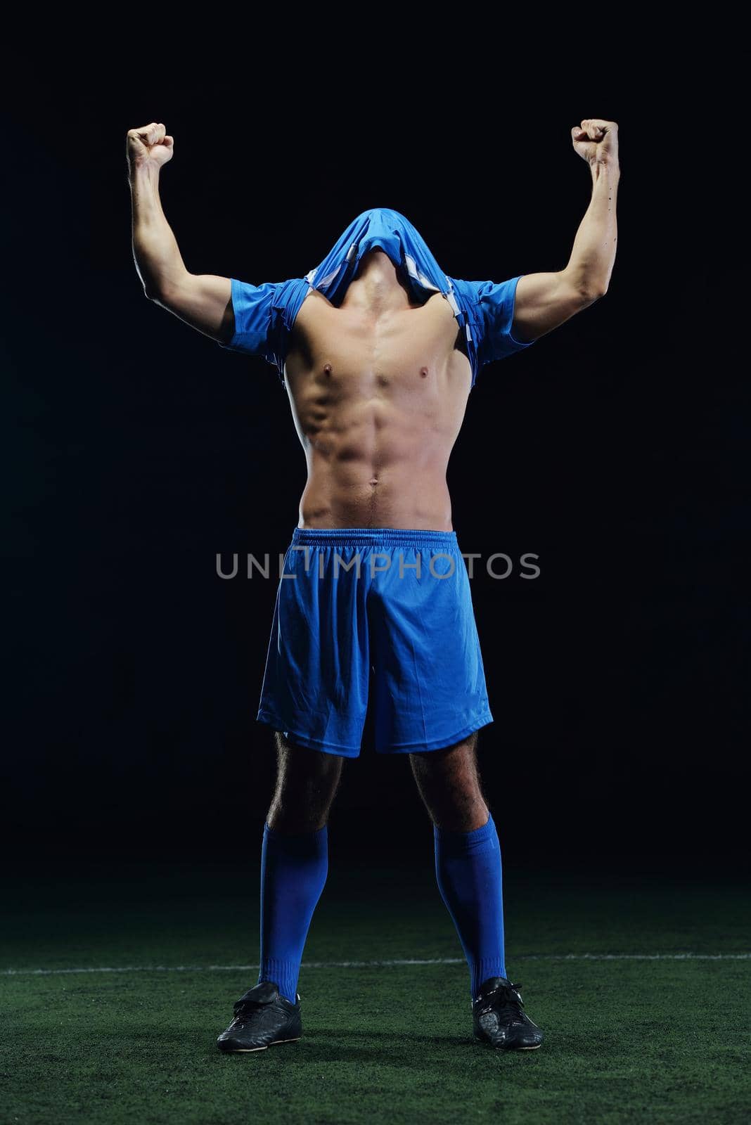 soccer player doing kick with ball on football stadium  field  isolated on black background