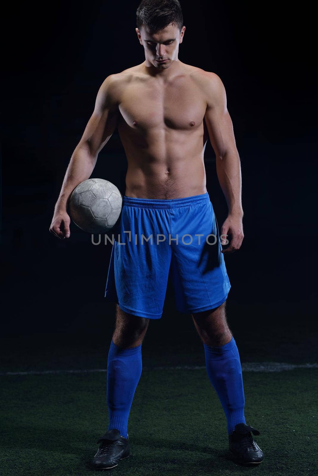 soccer player doing kick with ball on football stadium  field  isolated on black background