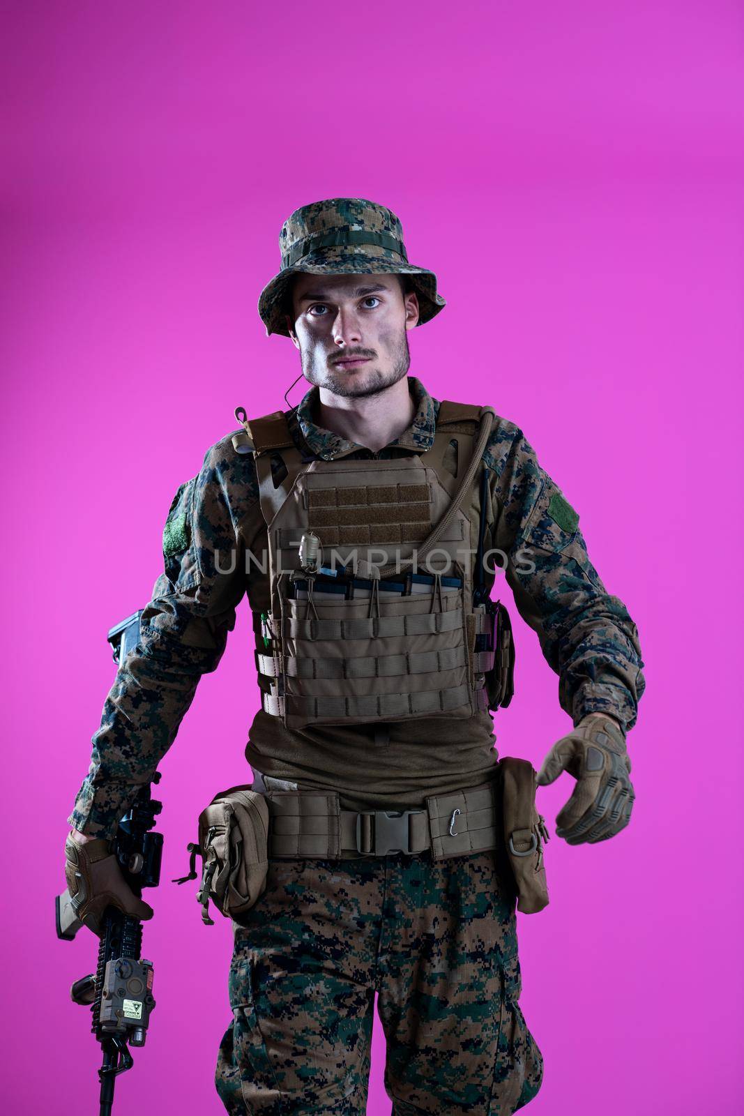 american  marine corps special operations modern warfare soldier with fire arm weapon and protective army tactical gear ready for battle on pink background