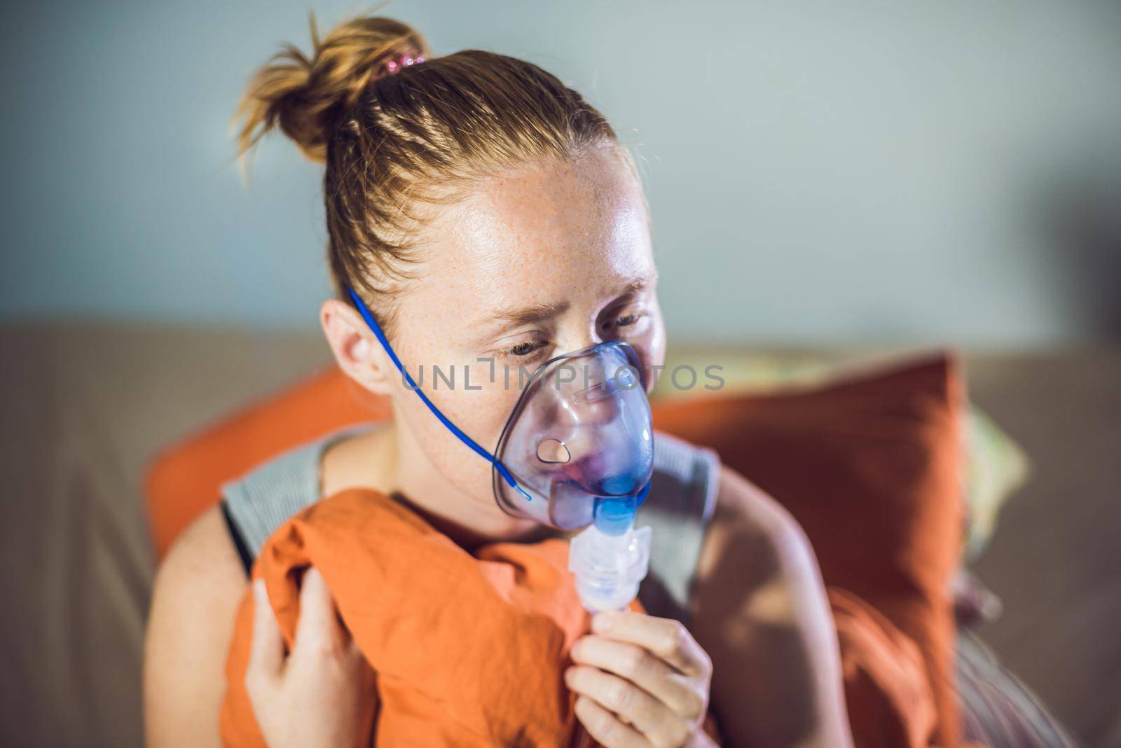 Woman with flu or cold symptoms making inhalation with nebulizer - medical inhalation therapy by galitskaya