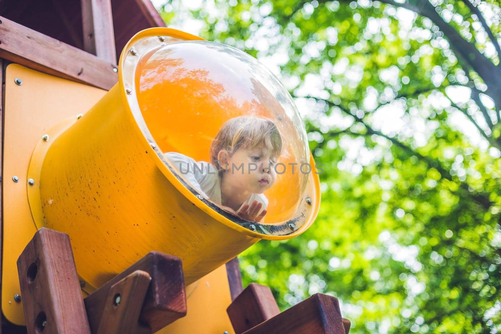 Cute little boy is playing on a wooden playground.