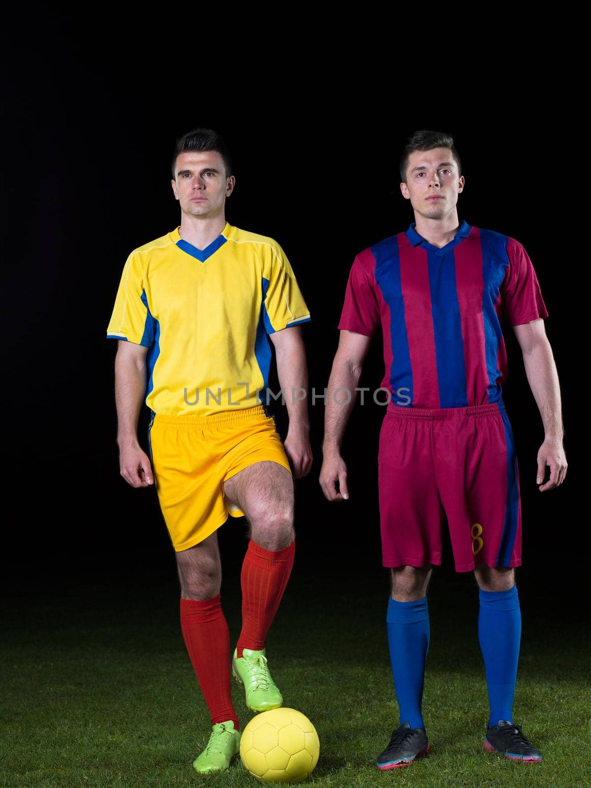 soccer player doing kick with ball on football stadium  field  isolated on black background