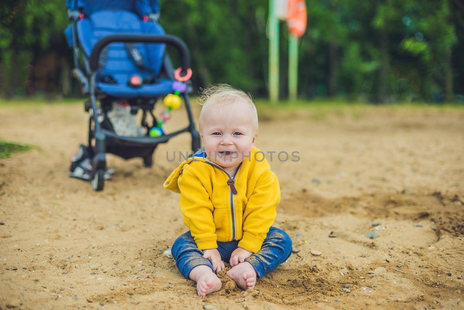 Toddler boy playing with sand on the beach development of fine motor skills by galitskaya