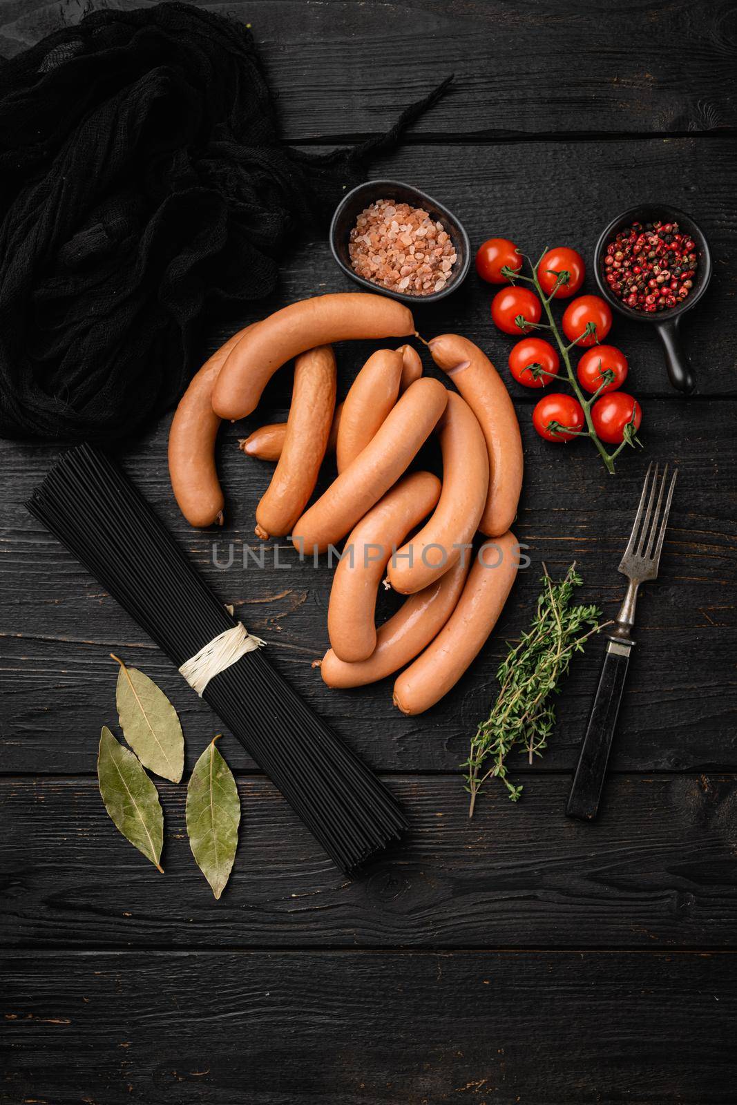 Classic boiled meat pork sausages set, on black wooden table background, top view flat lay