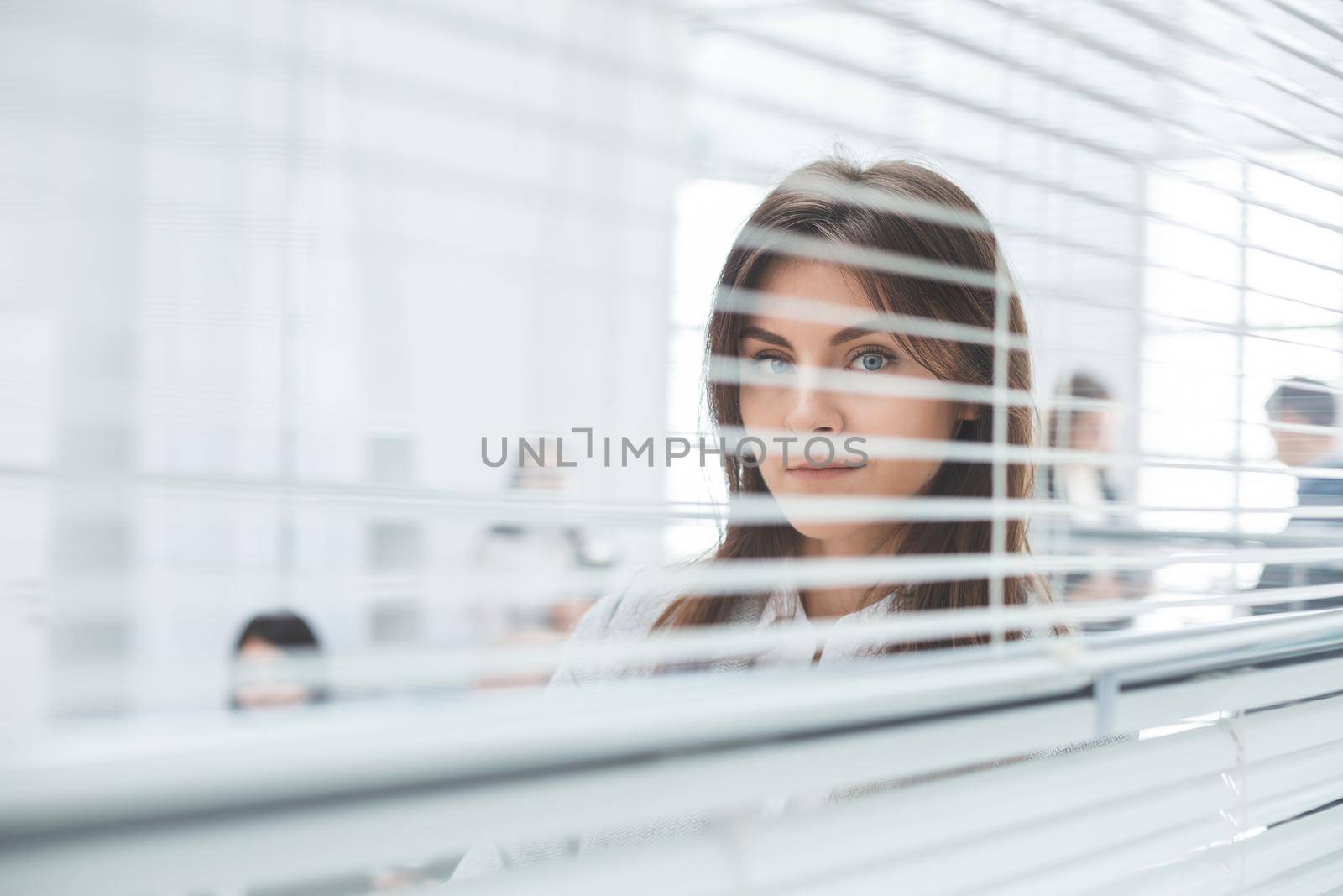 close up. young business woman looking through office window