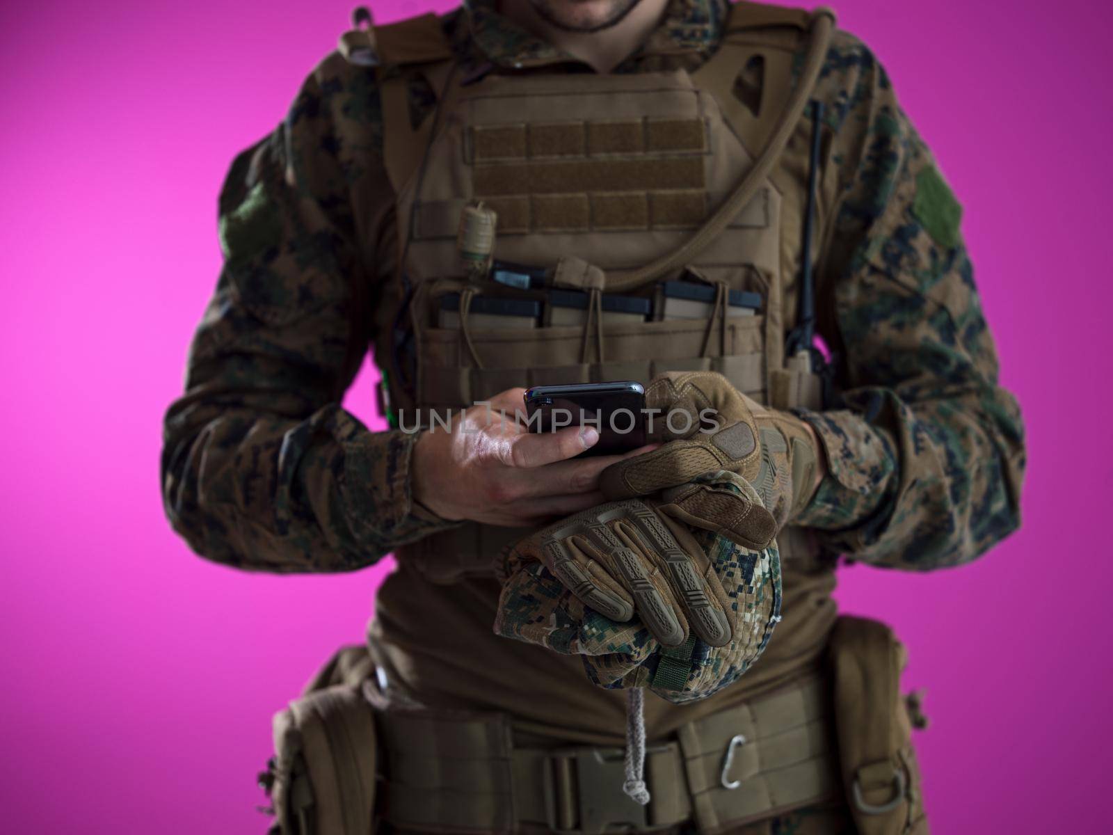 army soldier using smartphone to contact family or girlfriend communication and nostalgia concept pink background