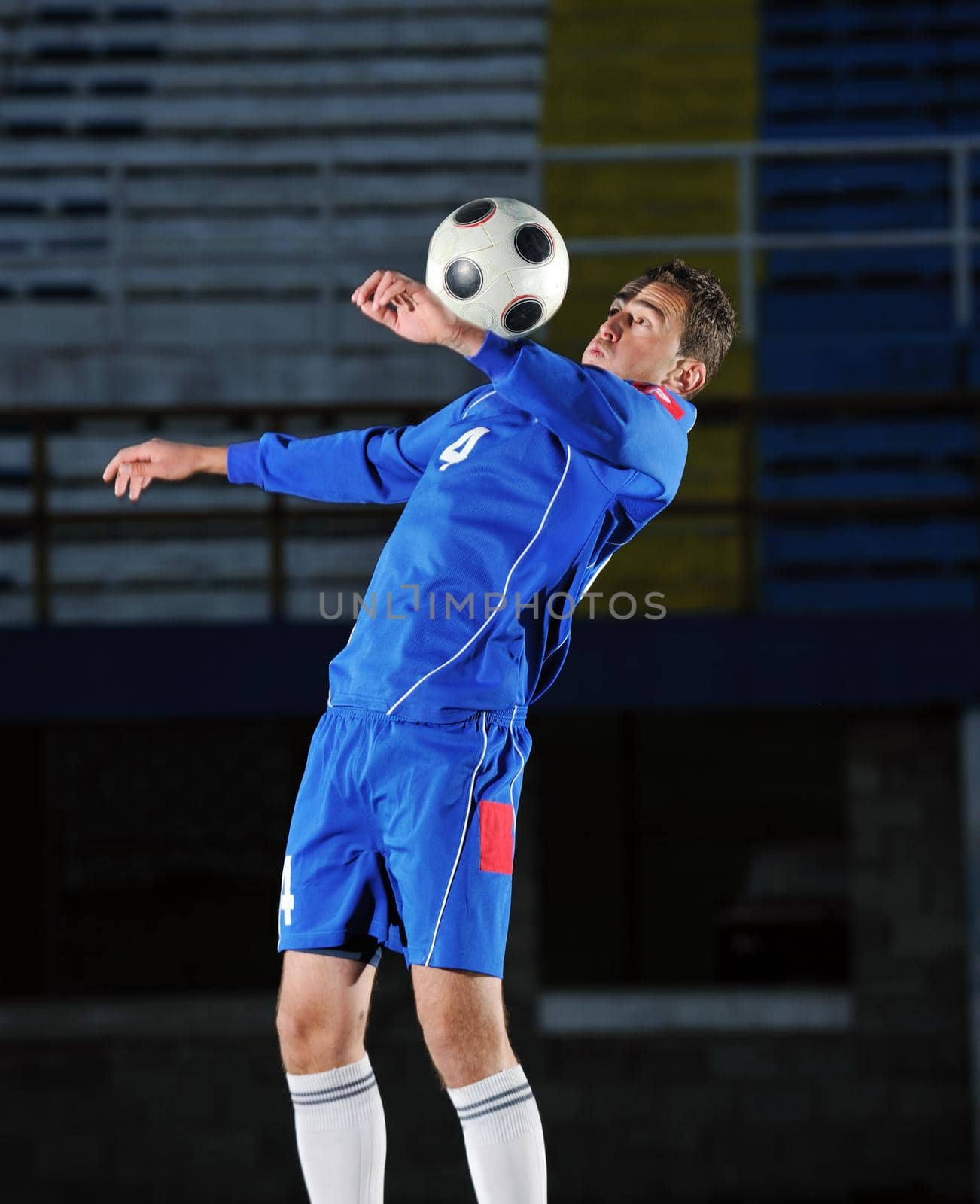 soccer player doing kick with ball on football stadium  field  isolated on black background  in night