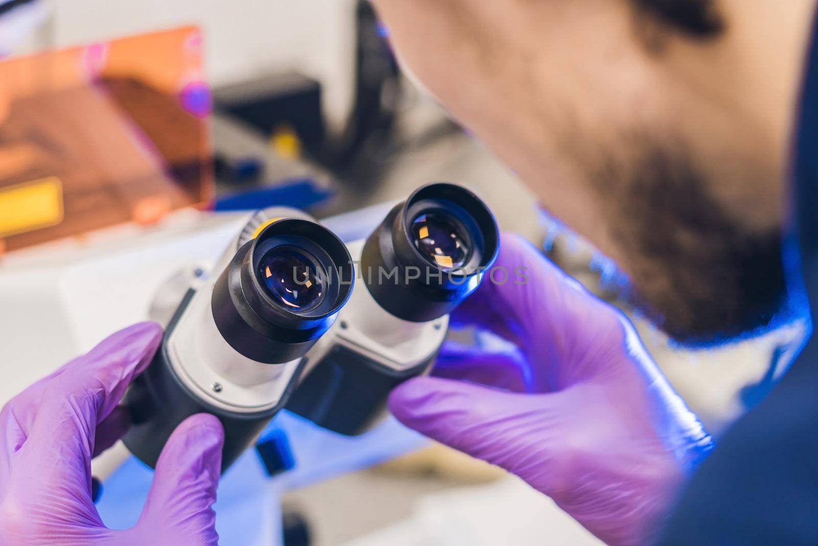 Scientist work on a confocal scanning microscope in a laboratory for biological samples investigation by galitskaya