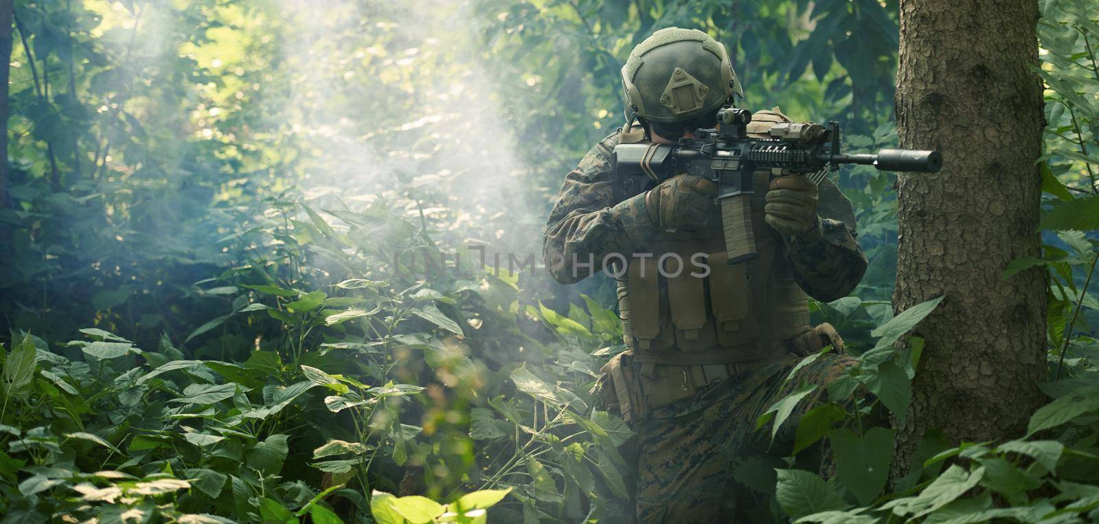 soldier in action aiming  on weapon  laser sight optics by dotshock