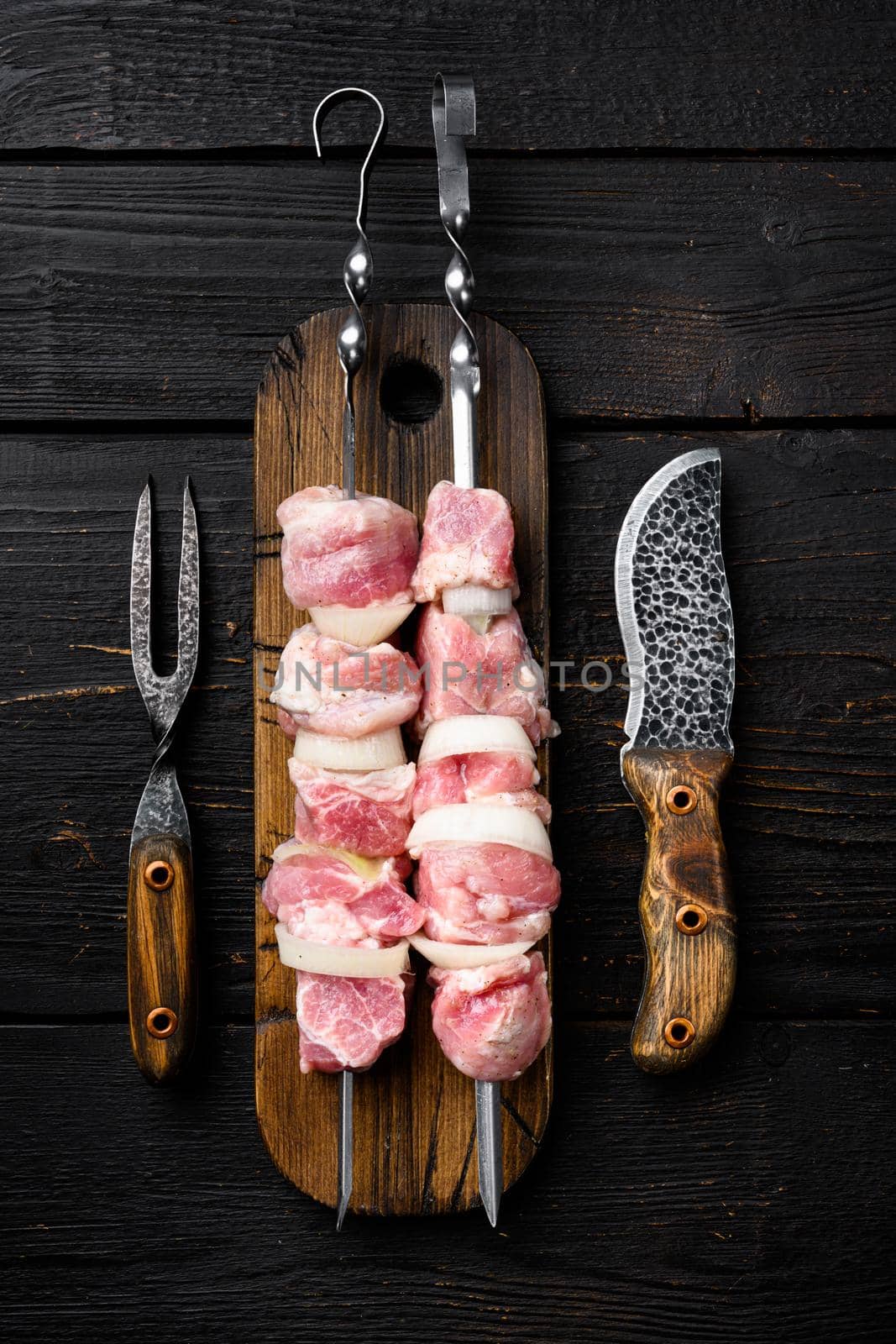 Raw kebab set, top view flat lay, on black wooden table background