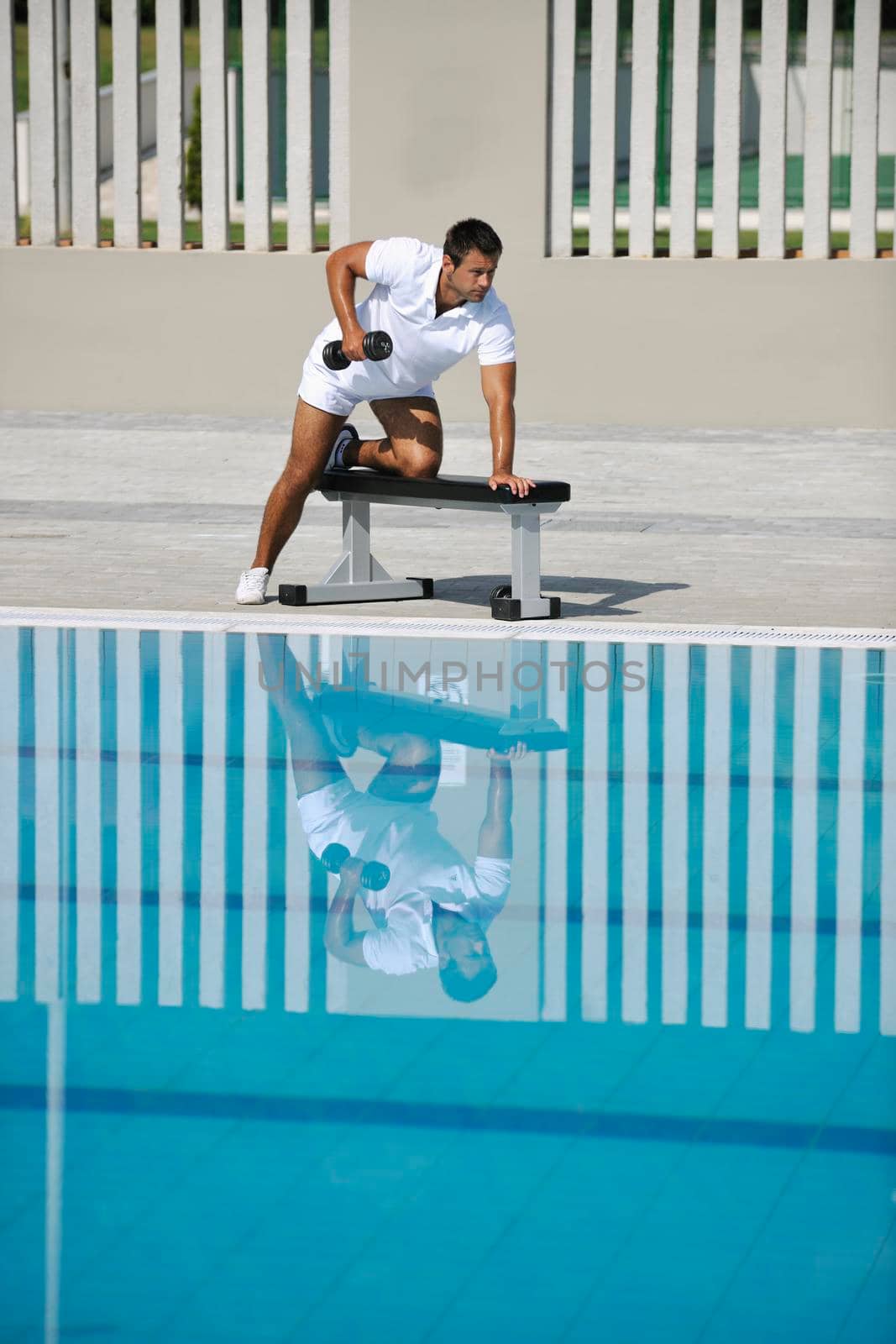 young healthy athlete man exercise at poolside