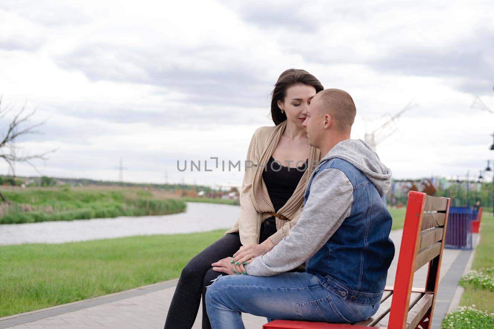 beautiful young couple sitting on a bench in the park.