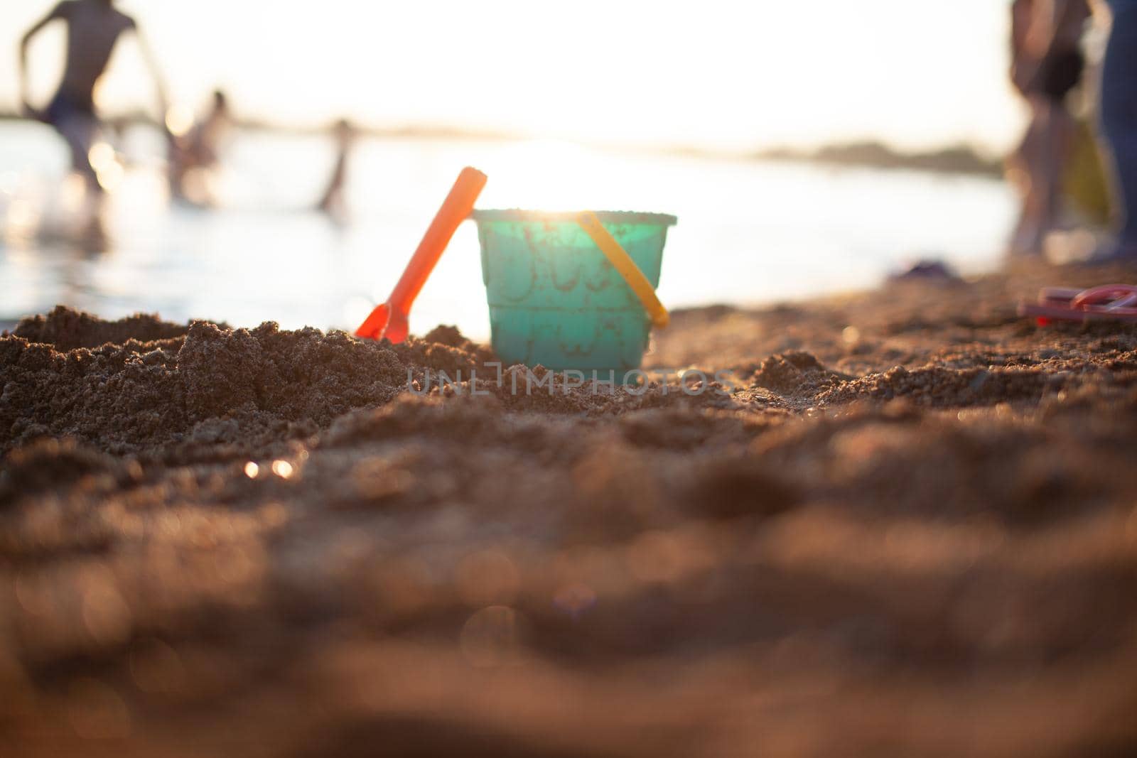 Children's toys for playing on the sand, a bucket and a rake on shore by AnatoliiFoto