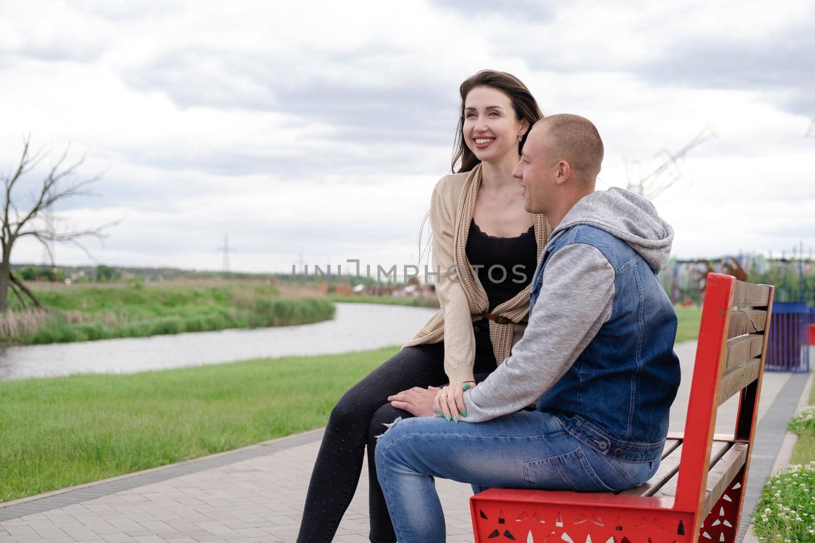 beautiful young couple sitting on a bench in the park.