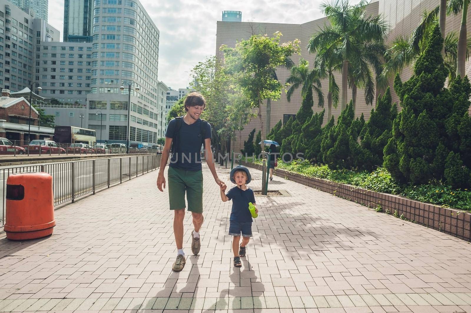 Father and son are walking around Hong Kong. Traveling with children concept.