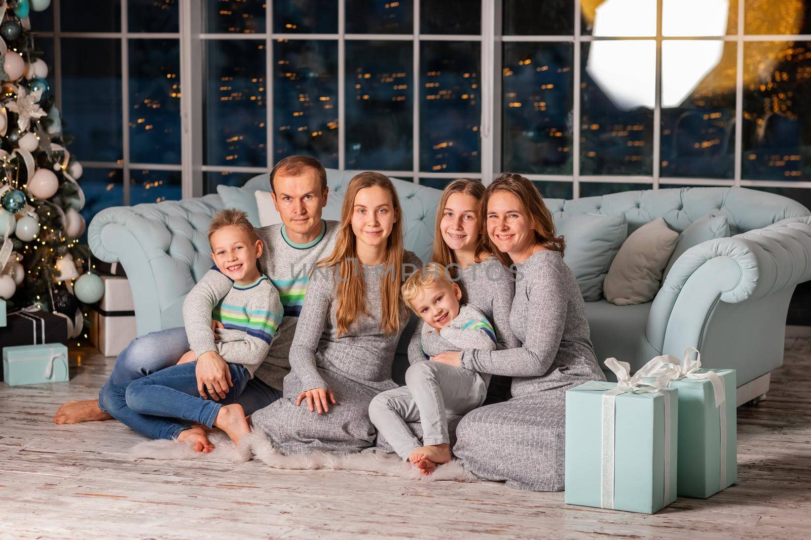 Big happy family with many kids having fun on the sofa near the Christmas tree on Christmas eve by Len44ik