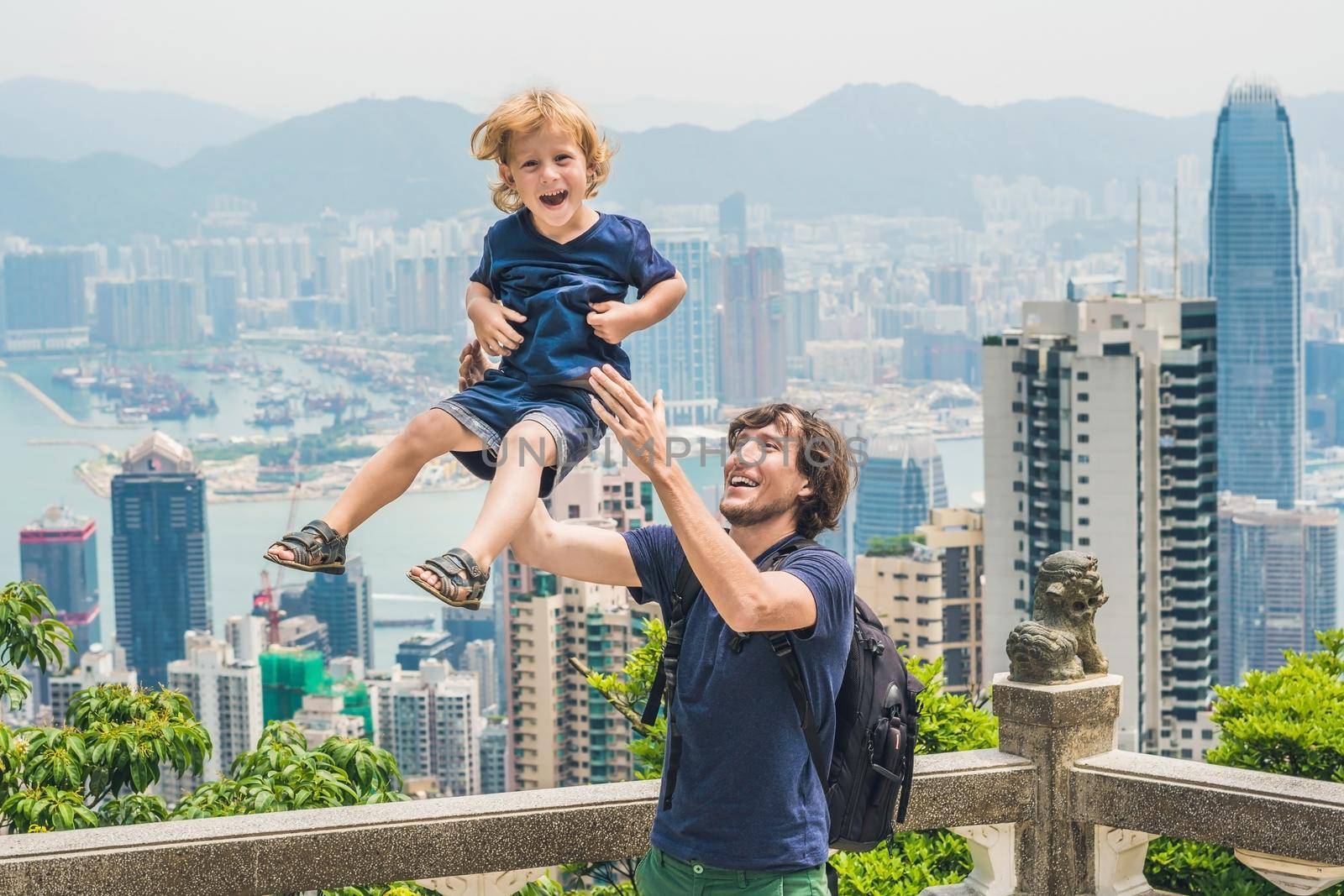 Father and son travelers at the peak of Victoria against the backdrop of Hong Kong. Traveling with children concept.