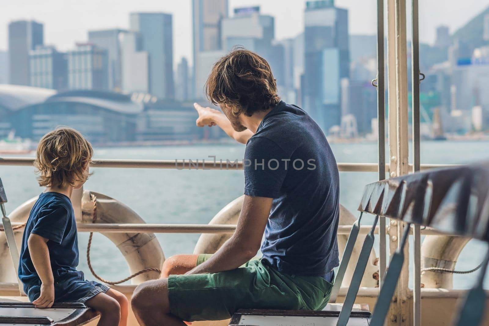 Father and son swim by ferry through victoria harbor in Hong Kong,China.