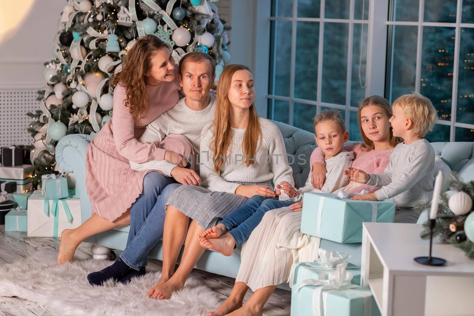 Big happy family with many kids having fun on the sofa near the Christmas tree on Christmas eve by Len44ik