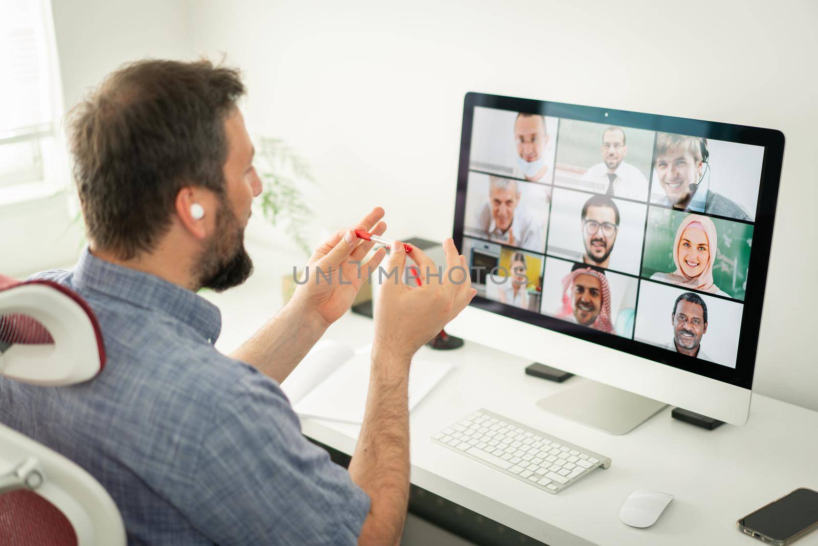 Mid adult man having online conference working at home