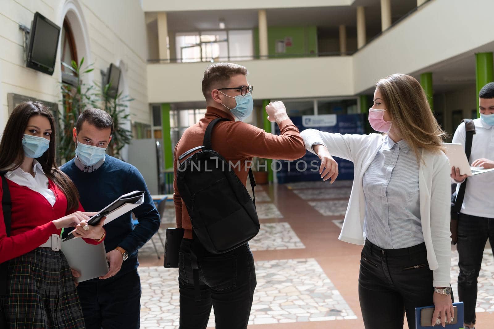 students greeting new normal coronavirus handshake and elbow bumping by dotshock