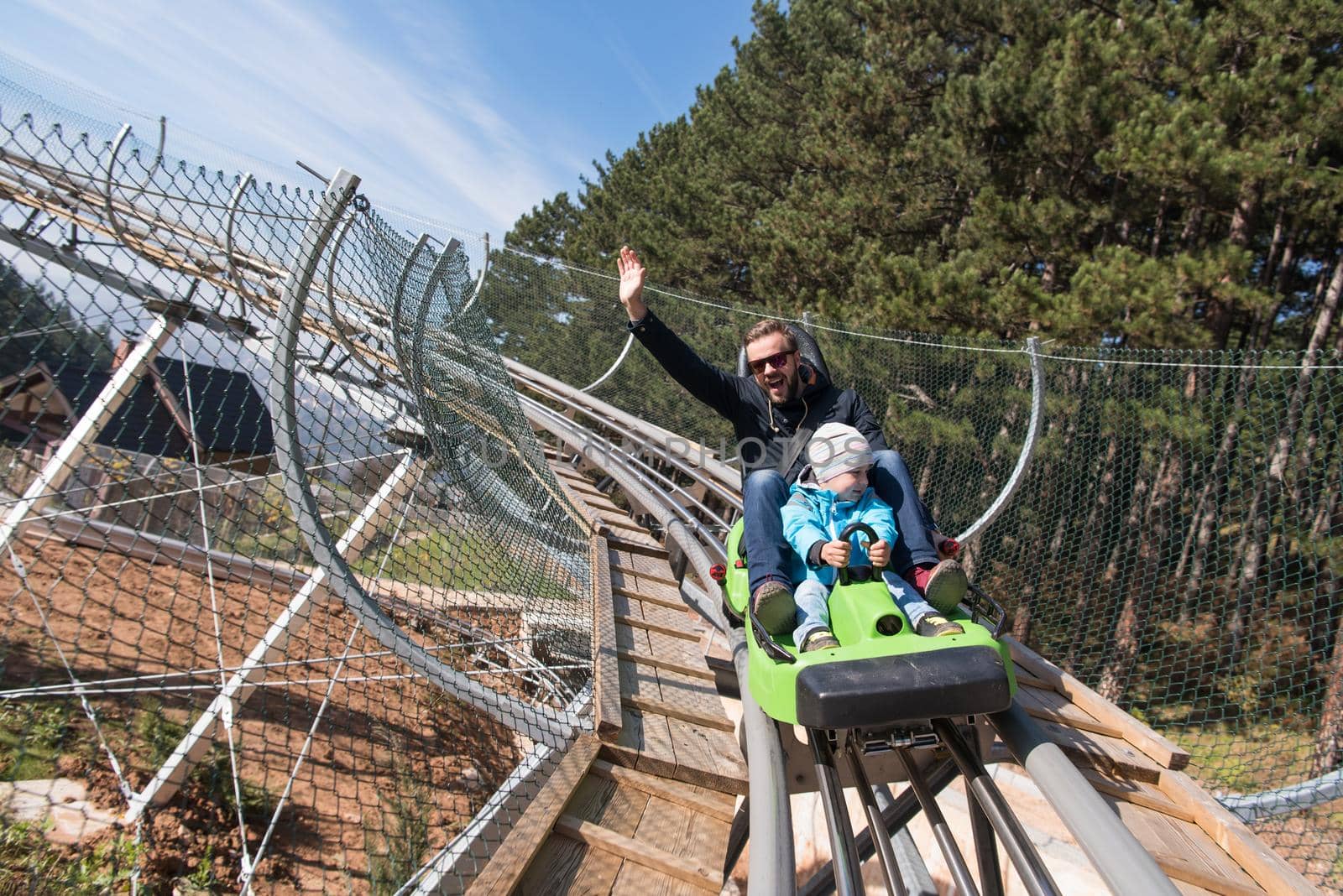 father and son enjoys driving on alpine coaster by dotshock