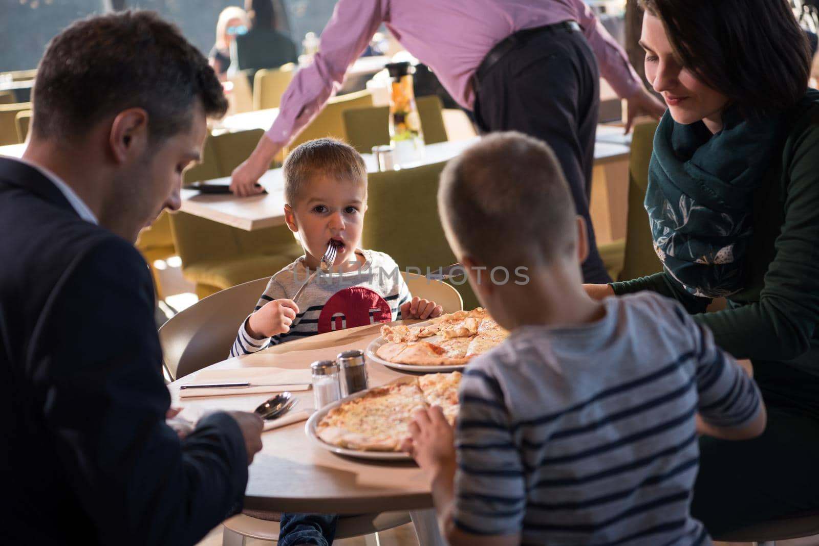Young parents enjoying lunch time with their children at a luxury restaurant