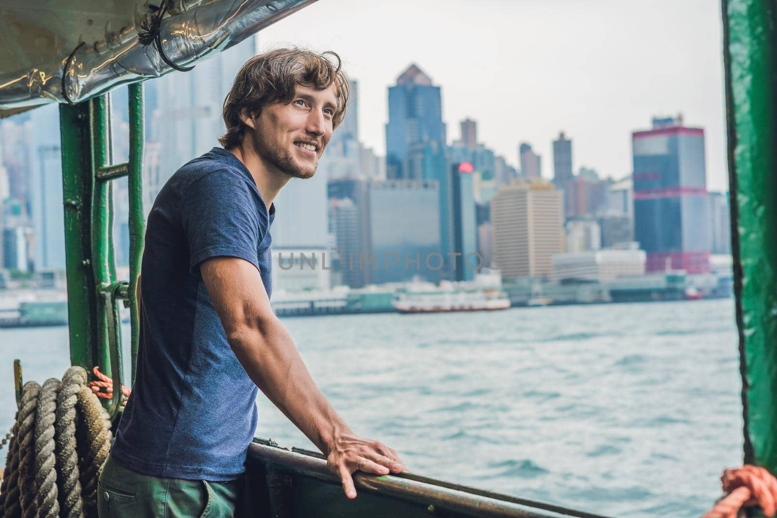 A young man on a ferry in Hong Kong by galitskaya