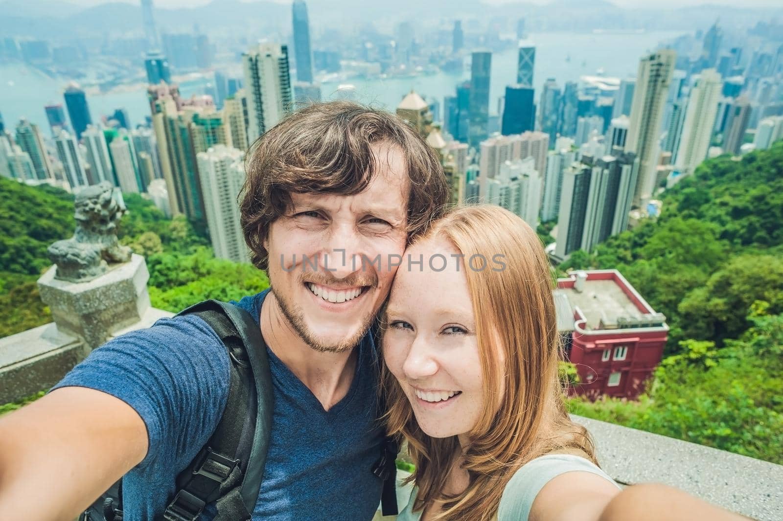 Caucasian couple in Hong Kong. Young people taking selfie picture at viewpoint of famous attraction Victoria Peak, HK, China.