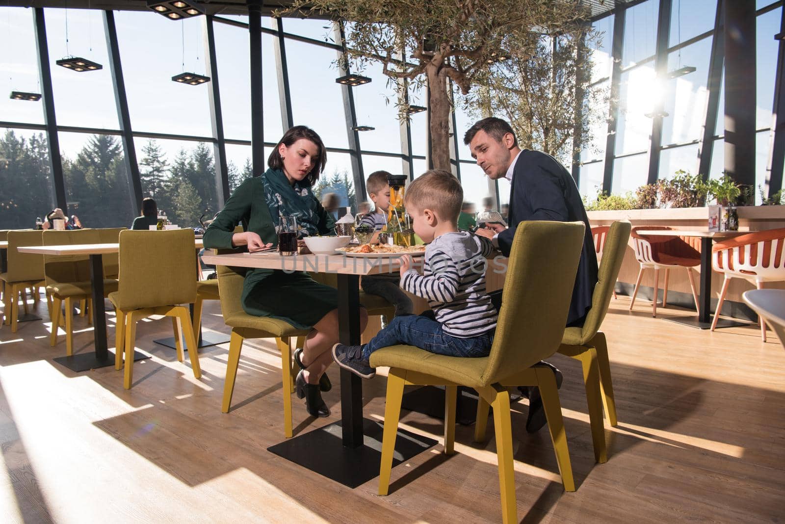 Young parents enjoying lunch time with their children at a luxury restaurant