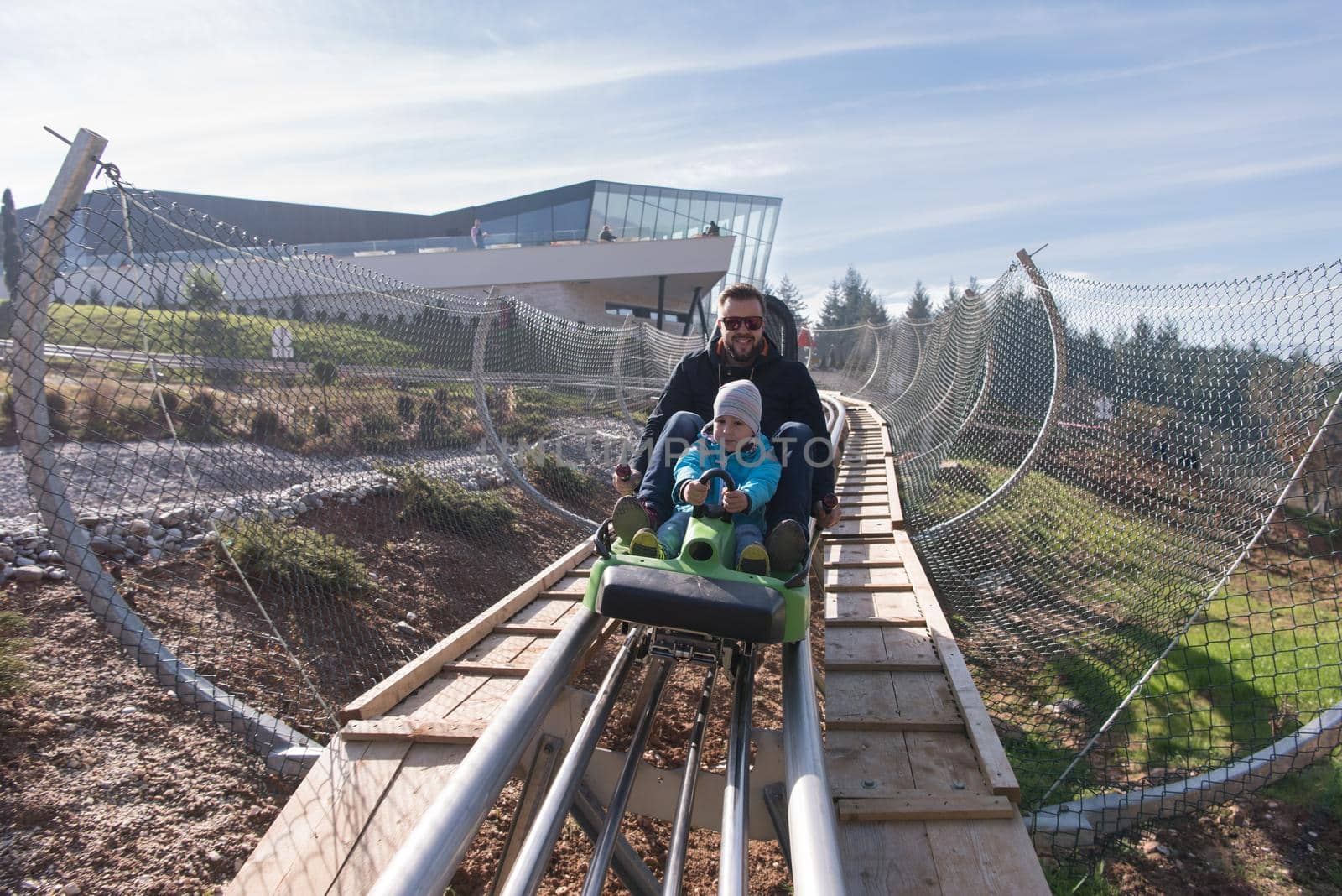 father and son enjoys driving on alpine coaster by dotshock