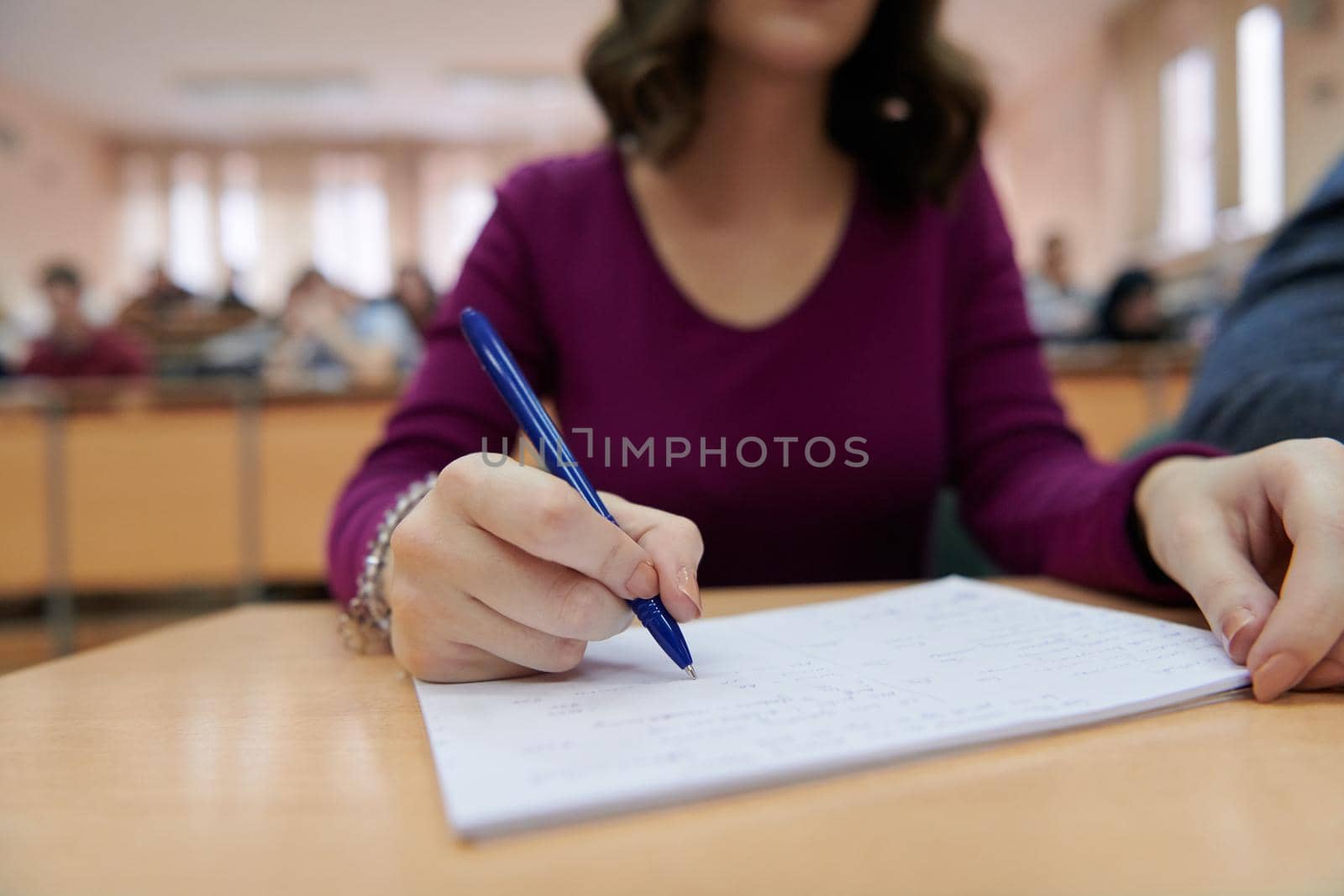 a beautiful female student uses a notebook and pen for school projects