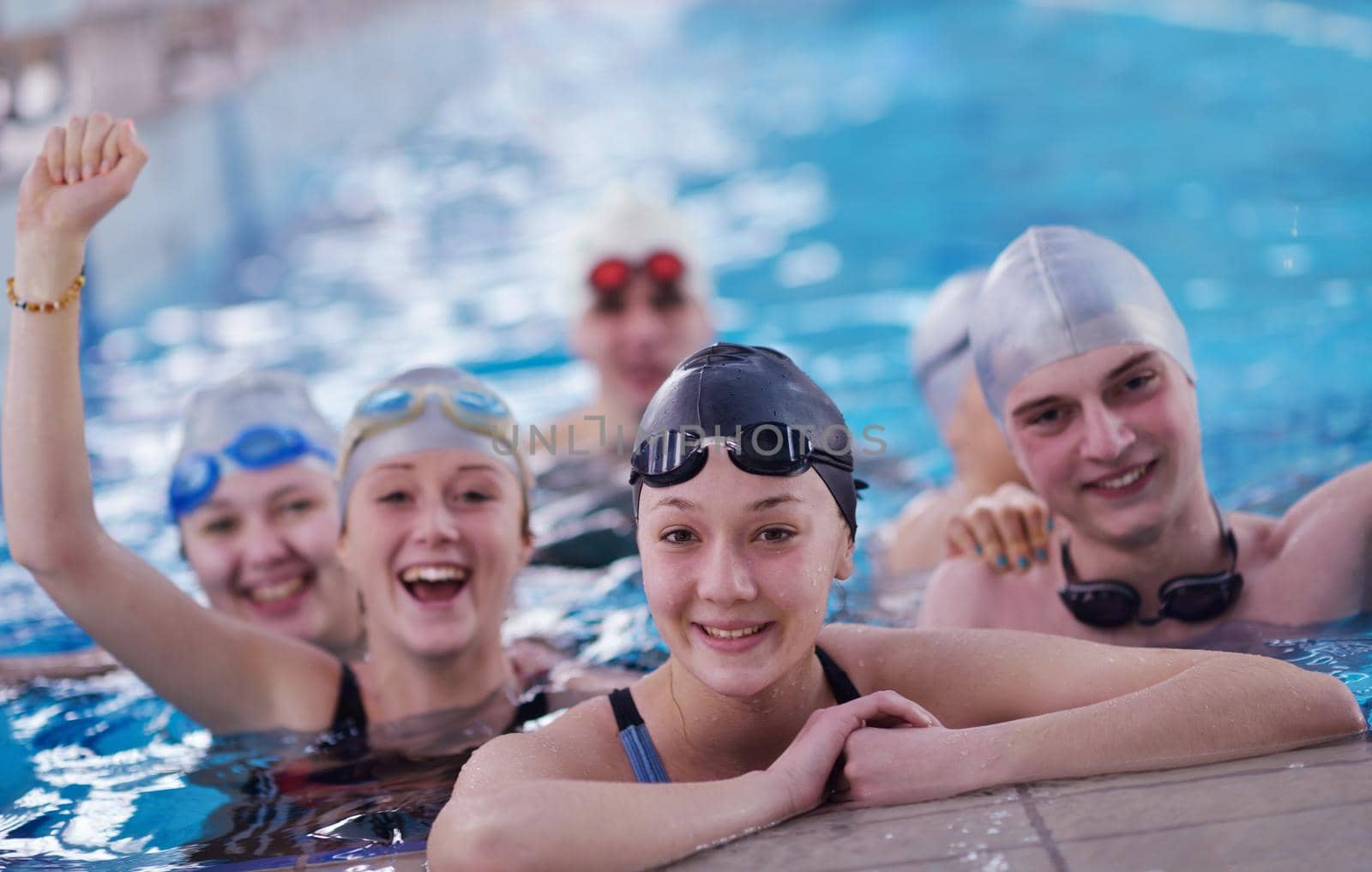 happy teen group  at swimming pool by dotshock