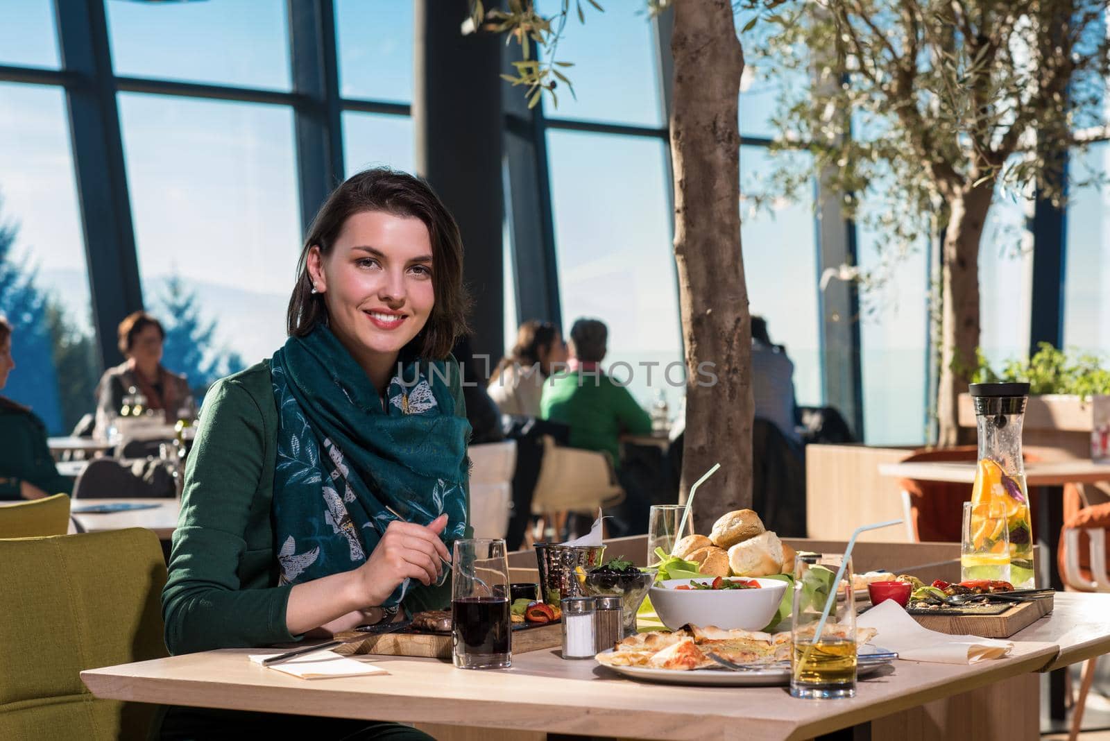 young woman looking happy while having lunch at luxury restaurant
