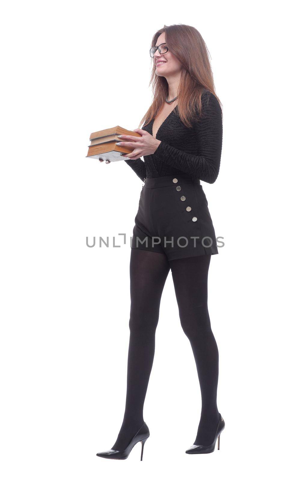 in full growth. a smiling young woman with a stack of books striding forward . isolated on a white background.