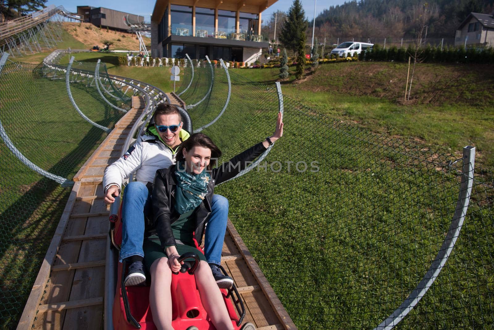 couple enjoys driving on alpine coaster by dotshock