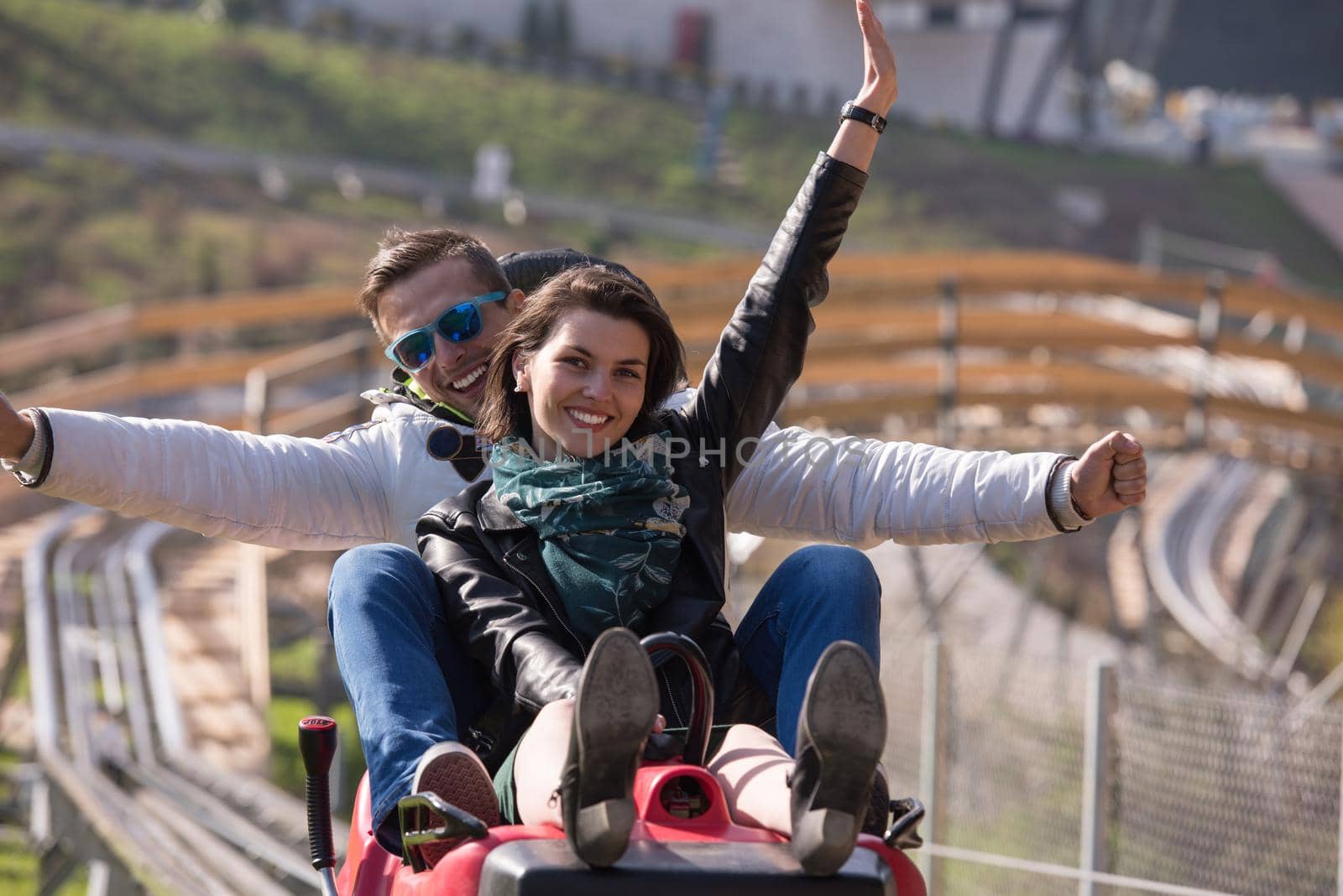 Excited young couple enjoys driving on alpine coaster