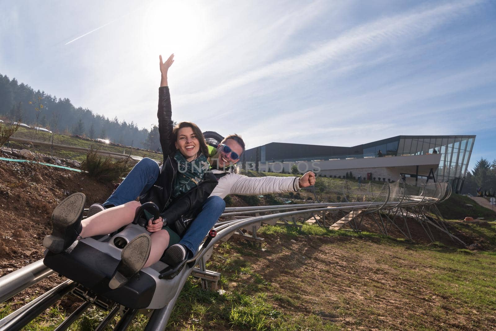 Excited young couple enjoys driving on alpine coaster