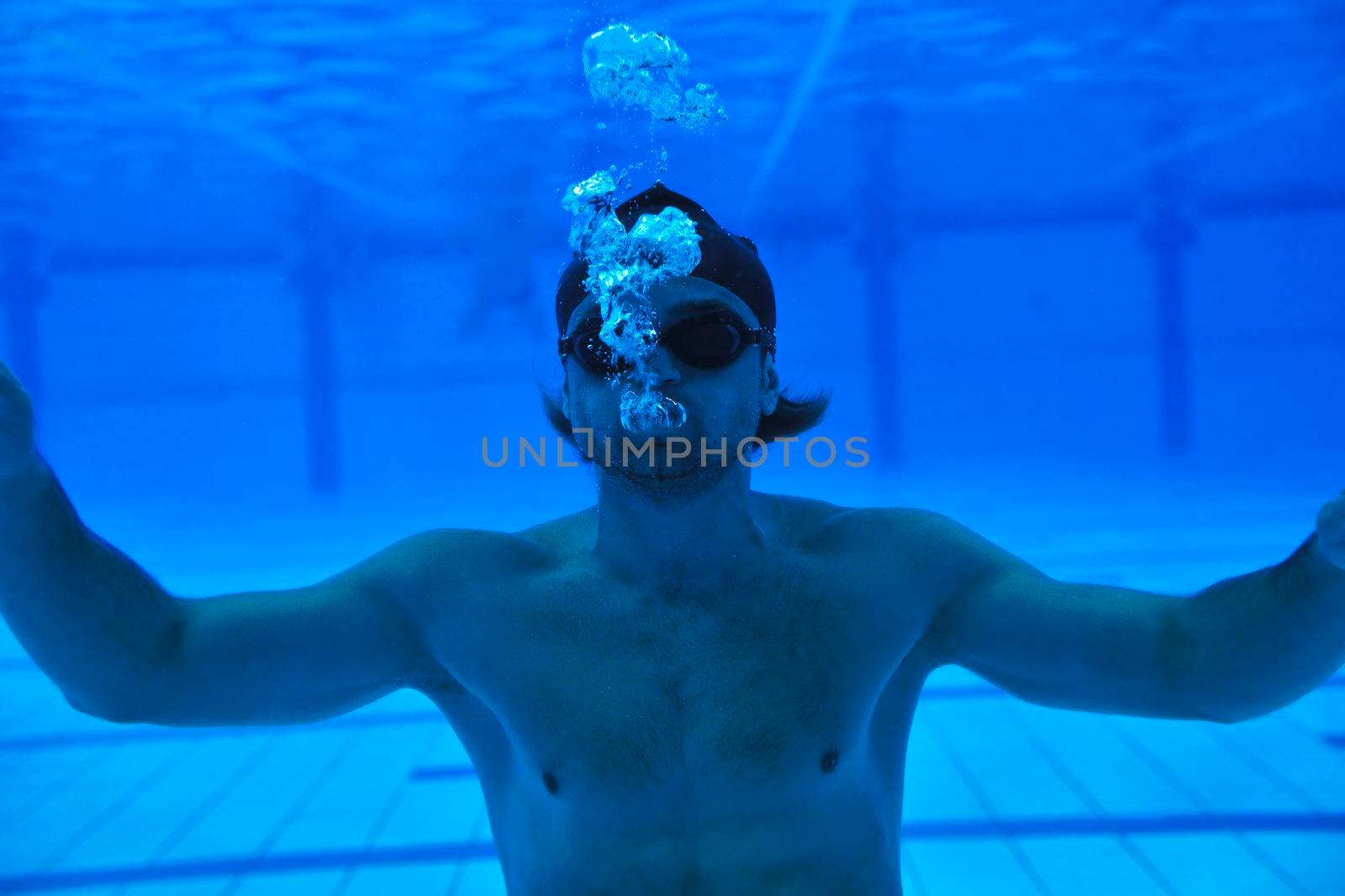 undervater shoot of swimming pool with good looking young swimmer 