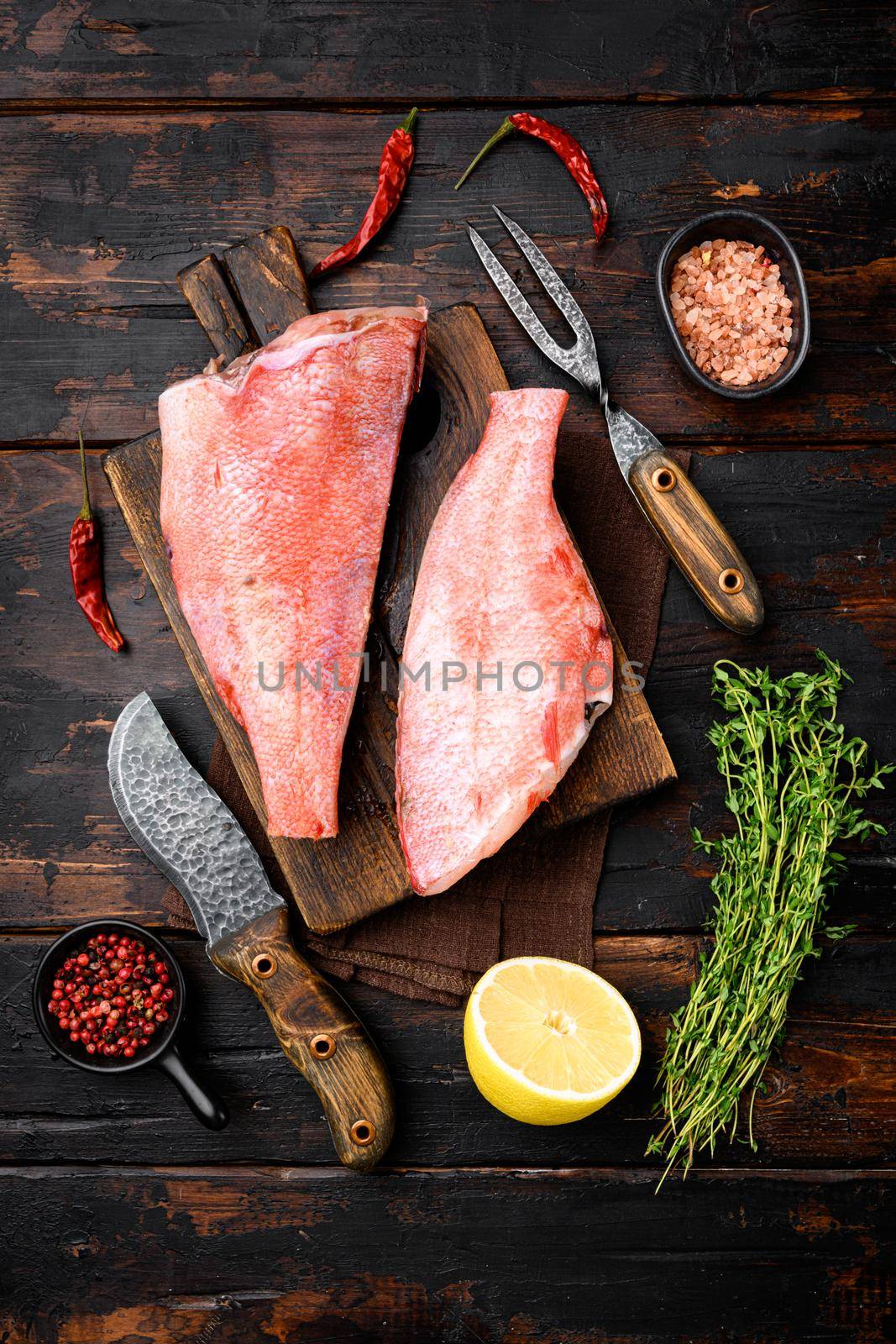 Fish raw snapper set, on wooden cutting board, on old dark wooden table background, top view flat lay