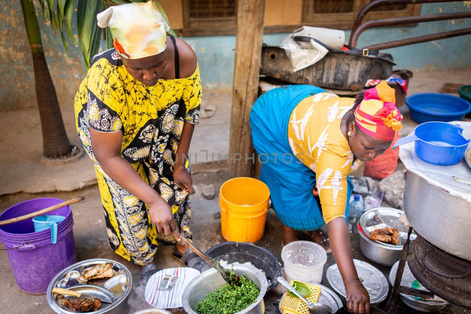 African woman cooking traditional food at street