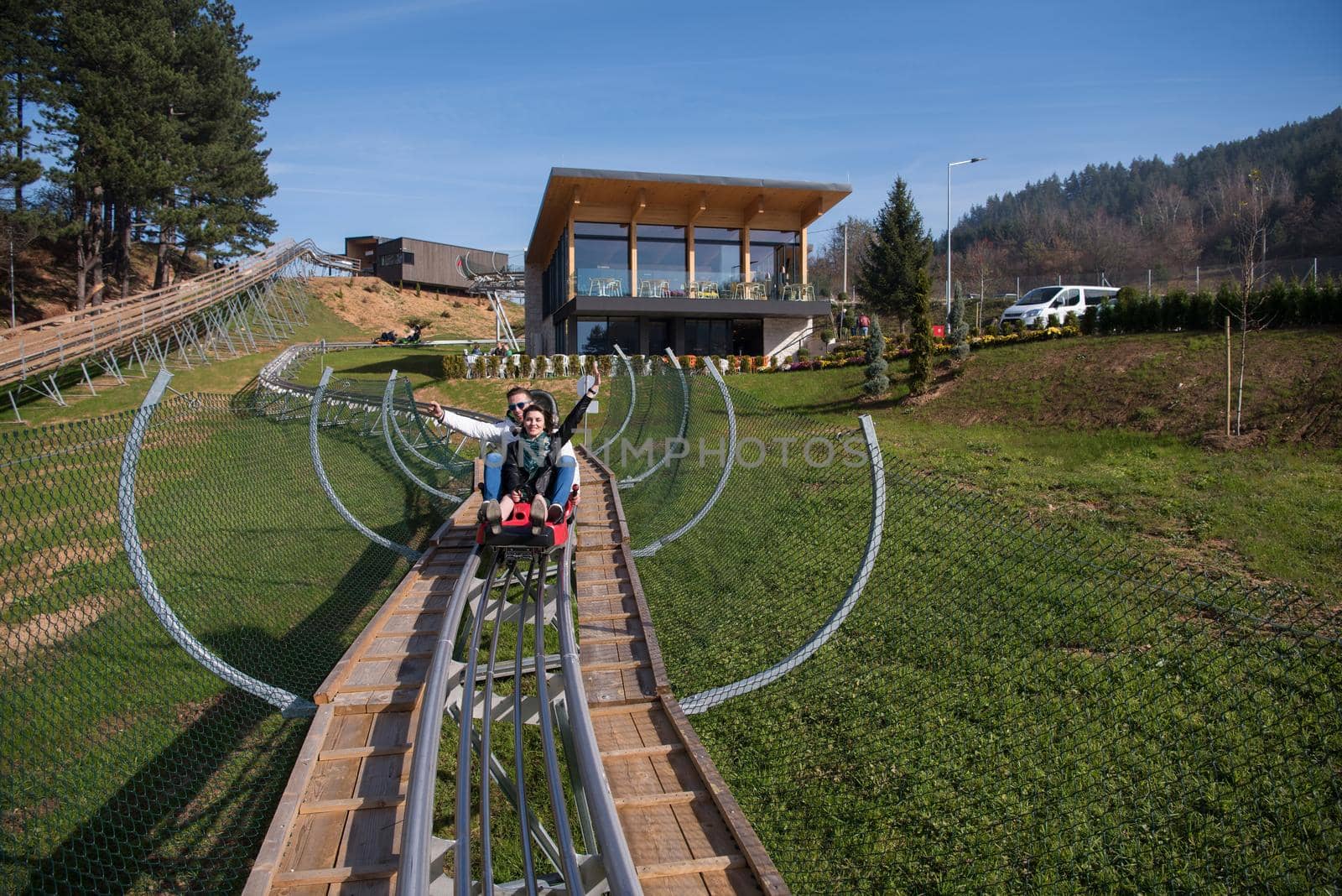 Excited young couple enjoys driving on alpine coaster