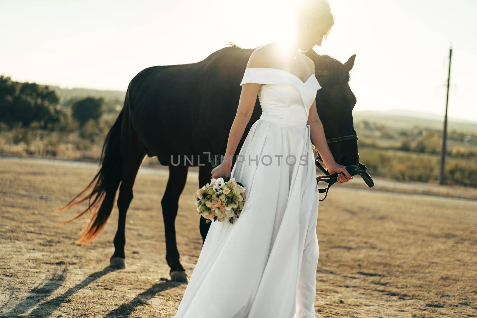 Portrait of a beautiful bride standing with horse