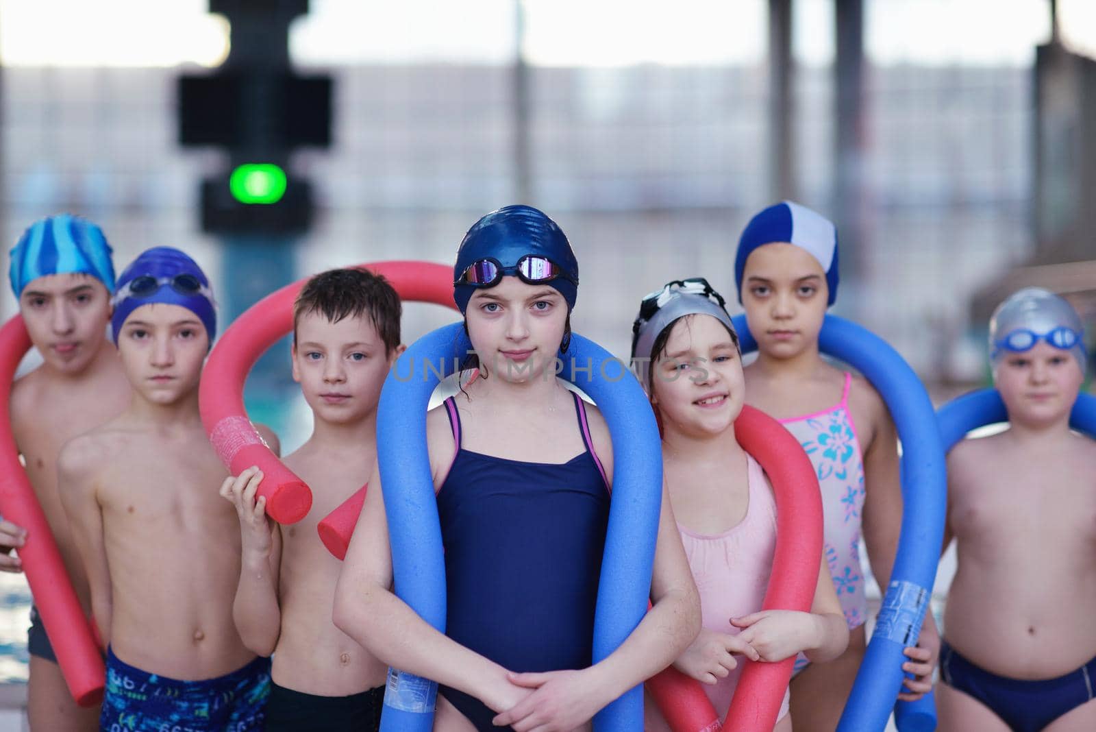 happy children kids group  at swimming pool class  learning to swim