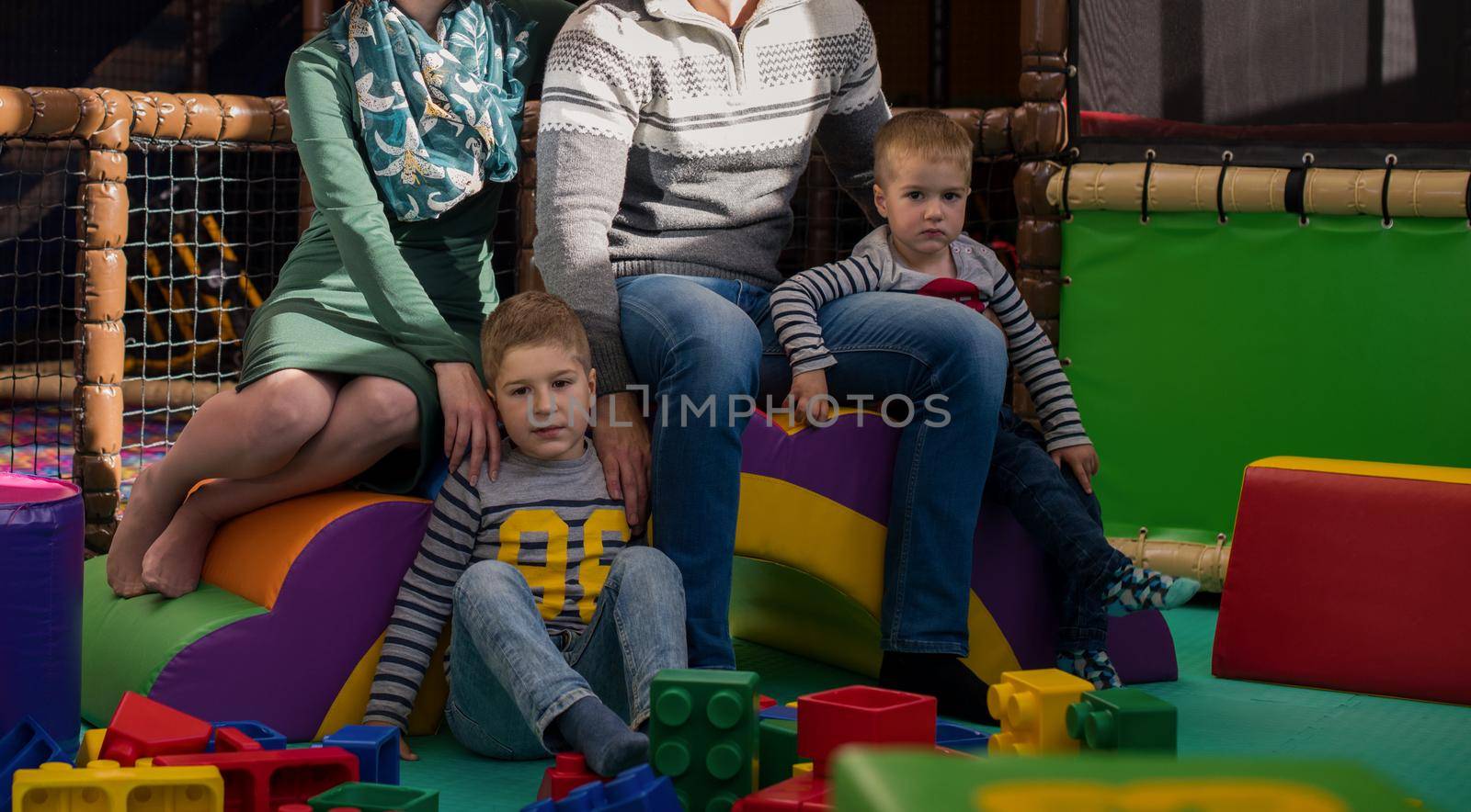 young parents and kids having fun at childrens playroom by dotshock