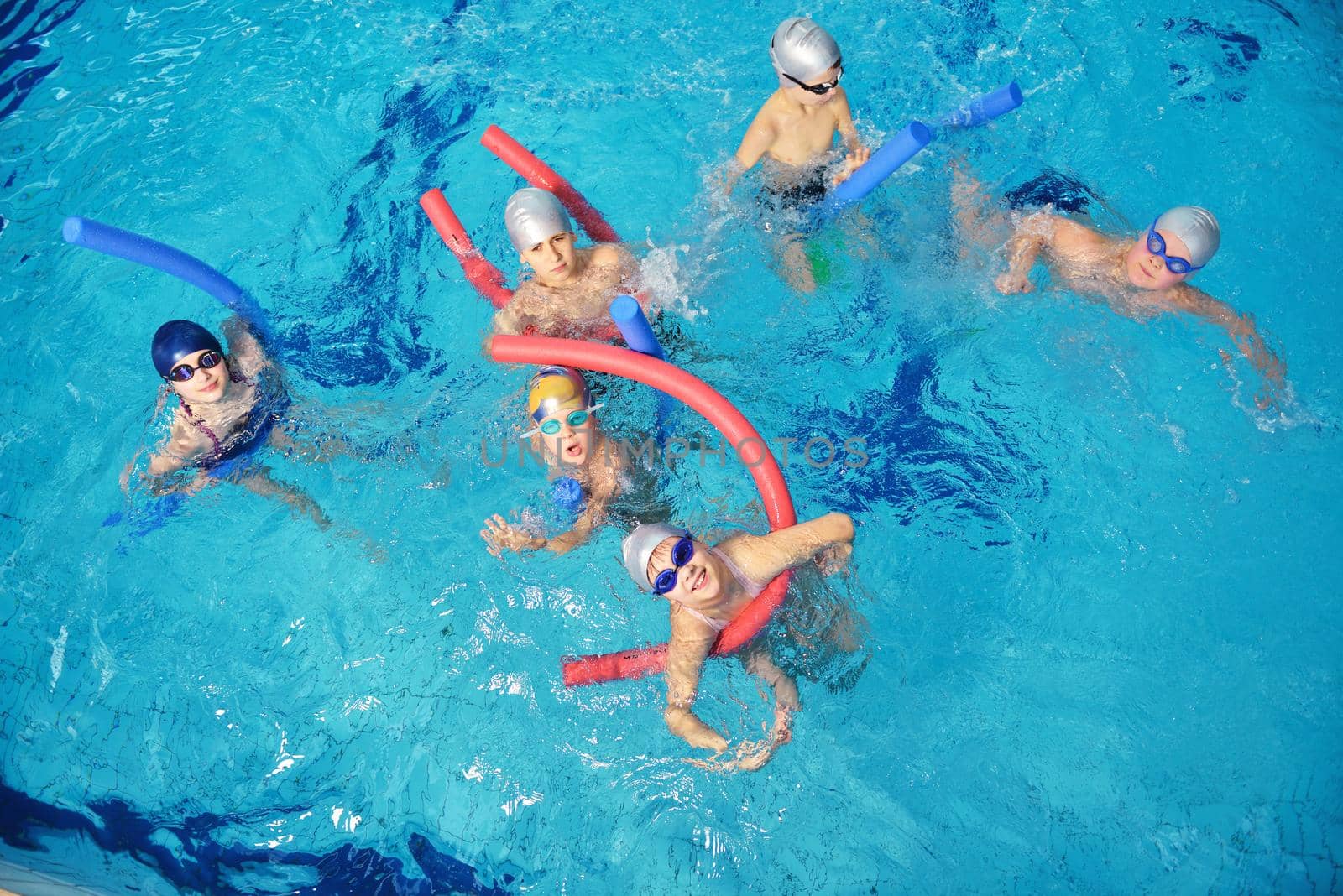 happy children kids group  at swimming pool class  learning to swim