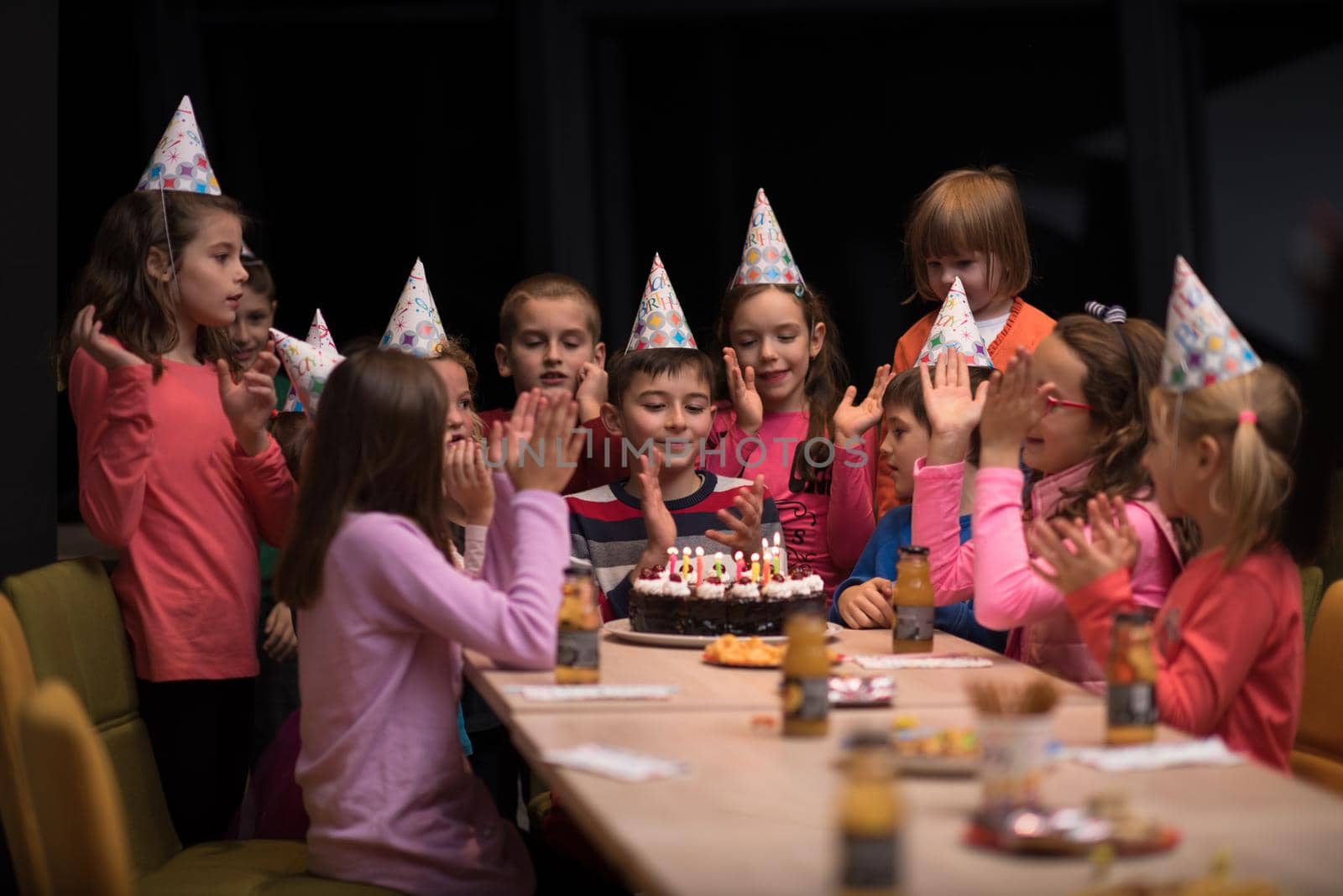 The young boy joyfully celebrating his birthday with a group of his friends